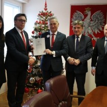 Powiększ zdjęcie Od%20prawej%20stoją:%20Wicestarosta%20Łukasz%20Karpiński,%20doradca%20Wojewody%20Andrzej%20Pruś,%20Wojewoda%20Świętokrzyski%20Zbigniew%20Koniusz%20trzyma%20w%20ręku%20druk%20umowy%20drugą%20rękę%20podaje%20Staroście%20Włoszczowskiemu%20Dariuszowi%20Czechowskiemu,%20Skarbnik%20Powiatu%20Agnieszka%20Górska.%20