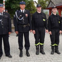 Powiększ zdjęcie Komendant Powiatowy PSP we Włoszczowie st. kpt. Andrzej Pacanowski, Wójt Gminy Krasocin Irezeusz Glisciński z odznaczonymi druhami z Oleszna 