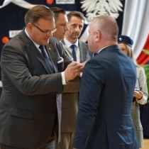 Powiększ zdjęcie Minister Jan Józef Kasprzyk odznacza Wicestarostę Włoszczowskiego Łukasza Karpińskiego. 