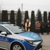 Powiększ zdjęcie Nowy radiowóz, przy którym stoi z modlitewnikiem i kropidłem Ksiądz Kanonik Leszek Dziwosz, w tle od prawej: Burmistrz Grzegorz Dziubek, Starosta Dariusz Czechowski, Wójt Secemina Tadeusz Piekarski, Komendant Policji insp. Mariusz Przyborowski.