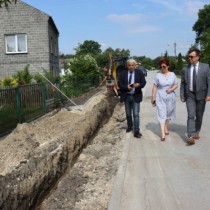 Powiększ zdjęcie Przewodniczący Rady Powiatu Włoszczowskiego Zbigniew Matyśkiewicz, Członek Zarządu Powiatu Małgorzata Gusta i Starosta Włoszczowski Dariusz Czechowski przy budowanym chodniku w Tarnawej Górze