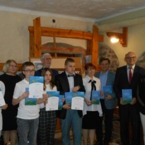 Powiększ zdjęcie Finał X Międzyszkolnego Konkursu Poetyckiego im. Łukasza Uniejewskiego. Zdjęcie zbiorowe: organizatorzy, goście i laureaci stoją pozukąc do wspólnego zdjęcia.