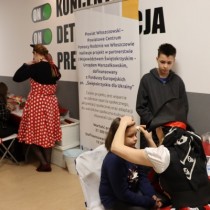 Powiększ zdjęcie Kącik malowania twarzy. Animatorka w stroju pirata maluje dziewczynkę, pod ścianą przygląda się im chłopiec.