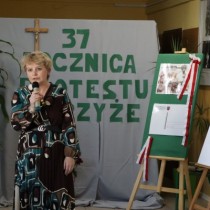 Powiększ zdjęcie Uczestniczka strajku Mariola Sosnowska trzyma mikrofon, przemawia do zebranych uczestników uroczystości z okazji 37. rocznicy protestu o krzyże w Zespole Szkół Zawodowych we Włoszczowie.