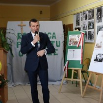 Powiększ zdjęcie Dyrektor Regionu Sieci Poczty Polskiej w Kielcach Wojciech Stelmach, trzyma mikrofon, przemawia do zebranych uczestników uroczystości z okazji 37. rocznicy protestu o krzyże w Zespole Szkół Zawodowych we Włoszczowie.