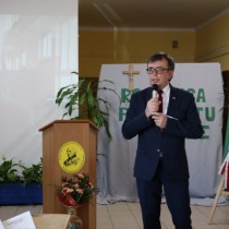 Powiększ zdjęcie Starosta Włoszczowski Dariusz Czechowski, trzyma mikrofon, przemawia do zebranych uczestników uroczystości z okazji 37. rocznicy protestu o krzyże w Zespole Szkół Zawodowych we Włoszczowie.