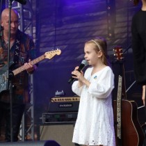 Powiększ zdjęcie Koncert zespołu Taraka z Amelią Anisovych (dziewczynka stoji w środku w białej sukience).
