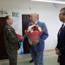 Powiększ zdjęcie Kwiaty Komendantowi Smerdzyńskiemu wręcza kierownik USC Urzędu Gminy Krasocin - Paweł Włodarski.