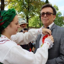 Powiększ zdjęcie Dekoracja kotylionem dożynkowym starosty włoszczowskiego Dariusza Czechowskiego.
