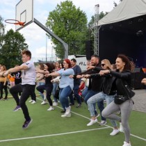Powiększ zdjęcie Uczestnicy imprezy promującej rodzicielstwo zastępcze w Powiatowym Centrum Kulturalno-Rekreacyjnym we Włoszczowie tańczą.