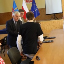 Powiększ zdjęcie Przewodniczący Rady Powiatu Zbigniew Matyśkiewicz wręcza uczestnikom materiały promocyjne Powiatu.