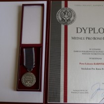 Powiększ zdjęcie Medal i Akt nadania Medalu „Pro Bono Poloniae” dla Łukasza Karpińskiego - Wicestarosty Włoszczowskiego.