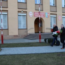 Powiększ zdjęcie Delegacja%20składa%20kwiaty%20i%20zapala%20znicz%20przed%20tablicą%20znajdującą%20się%20przed%20budynkiem%20starostwa