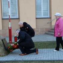 Powiększ zdjęcie Delegacja składa kwiaty i zapala znicz przed tablicą znajdującą się przed budynkiem starostwa