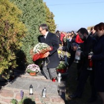 Powiększ zdjęcie Zarząd Powiatu Włoszczowskiego składa kwiaty i zapala znicz na jednym z grobów żołnierzy