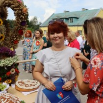 Powiększ zdjęcie Przypięcie kotylionu dożynkowego Członek Zarządu Powiatu Małgorzacie Guście