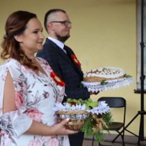 Powiększ zdjęcie Starostowie dożynek przekazują bochen chleba i kosz owoców władzom Powiatu Włoszczowskiego i Gminy Radków