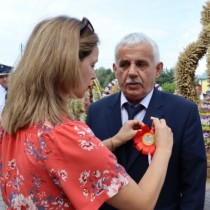 Powiększ zdjęcie Przypięcie kotylionu dożynkowego Przewodniczącemu Rady Powiatu Włoszczowskiego Zbigniewowi Matyśkiewiczowi