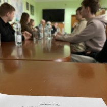 Powiększ zdjęcie Członkowie Młodzieżowej Rady Powiatu podczas obrad siedzą przy stole. Na pierwszym planie kartka z napisem: Posiedzenie wspólne Komisji Młodzieżowej Rady Powiatu Włoszczowskiego dnia 3 lutego 2023 r.