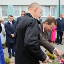 Powiększ zdjęcie Zaproszeni goście przecinają wstęgę, odsłaniając tablicę pamiątkową