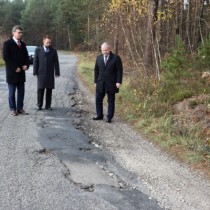 Powiększ zdjęcie Starosta Włoszczowski Dariusz Czechowski, Członek Zarządu Powiatu Rafał Pacanowski i Wicestarosta Łukasz Karpiński przygladają się uszkodzonej drodze powiatowej nr 1900T