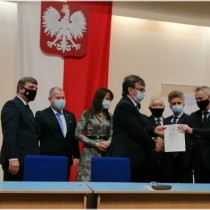 Powiększ zdjęcie Wojewoda Świętokrzyski przekazuje jeden egzemplarz podpisanej umowy Staroście Włoszczowskiemu