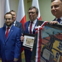 Powiększ zdjęcie Członek Zarządu Powiatu Rafał Pacanowski, Starosta Włoszczowski Dariusz Czechowski i Prezydent RP Andrzej Duda z upominkami wreczonymi sobie wzajemnie