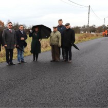 Powiększ zdjęcie Na remontowanej drodze stoją: Wicestarosta, Starosta Włoszczowski, Radny Sejmiku Województwa Świętokrzyskiego, Członek Zarządu Powiatu, Sołtys Ojsławic, Wójt Gminy Radków, Przewodniczący Rady Powiatu Włoszczowskiego 